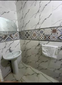 a bathroom with a white sink and marble walls at Pyramids Heritage suites in Ghaţāţī +35 photos