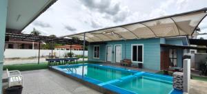 a house with a swimming pool and a building at Triple S Homestay Bachok in Bachok