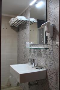 タオルミーナにあるレジデンス シルセのバスルーム(白い洗面台、鏡付)