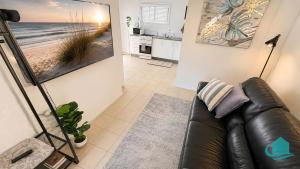 a living room with a couch and a painting on the wall at Coastal Hideaway at Pelican in Pelican Flat
