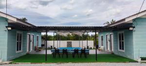 a blue house with a table and chairs on the patio at Triple S Homestay Bachok in Bachok