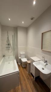 a bathroom with two sinks and a tub and a toilet at Rutland Home in Langham +31 photos