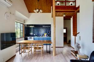 a kitchen and dining room with a wooden table and chairs at 海を望む東伊豆の一棟貸し ula Ocean-view private stay in Izu in Higashiizu