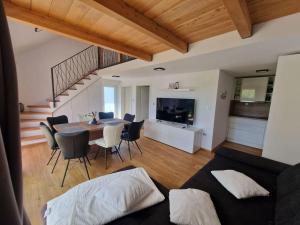 a living room with a table and chairs and a staircase at Počitniška hiša Maja v naravi in Planina pri Sevnici