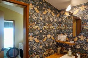 a bathroom with a wall with a floral wallpaper at 海を望む東伊豆の一棟貸し ula Ocean-view private stay in Izu in Higashiizu +22 photos