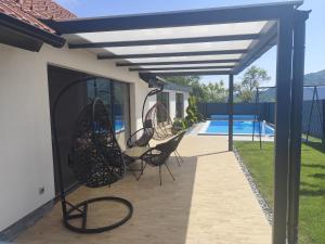 a patio with chairs under awning and a pool at Počitniška hiša Maja v naravi in Planina pri Sevnici