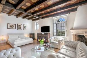 a living room with white furniture and a fireplace at Villa Schlosser Lake Front & Private Pool in Malcesine +35 photos