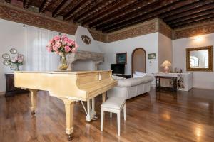a living room with a piano and a couch at Villa Schlosser Lake Front & Private Pool in Malcesine