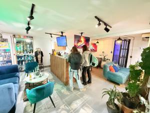 two people standing at a bar in a room at Bababuy Hostel in Bogotá