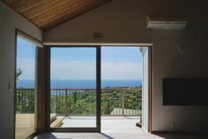 a room with a sliding glass door to a balcony at 海を望む東伊豆の一棟貸し ula Ocean-view private stay in Izu in Higashiizu