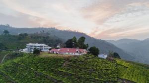 a farm on top of a hill with a house at Estate Bungalow with Waterfall, Mountain & Valley Views in Kotagiri +26 photos