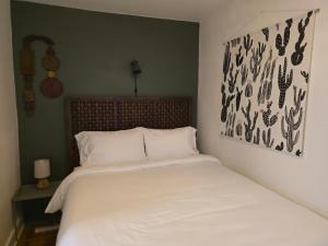 a bedroom with a white bed with a picture on the wall at Stylish Apt in Walker's Point in Milwaukee