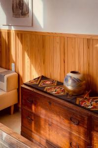 a wooden cabinet with a vase sitting on top of it at Guesthouse Nara IROHA in Nara