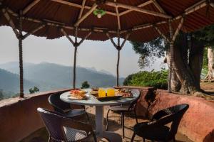 an outdoor table with chairs and a table with food on it at Estate Bungalow with Waterfall, Mountain & Valley Views in Kotagiri