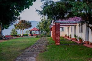a brick house with a gazebo in the background at Estate Bungalow with Waterfall, Mountain & Valley Views in Kotagiri