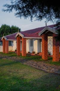 a brick house with a roof on a yard at Estate Bungalow with Waterfall, Mountain & Valley Views in Kotagiri