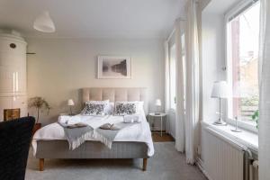 a white bedroom with a bed with two towels on it at C Apartments Annedal in Gothenburg