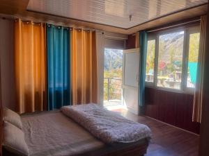 a room with a bed in front of a window at beheney Homestay gondhla in Kyelang
