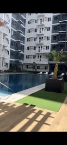 a large apartment building with a swimming pool and palm trees at Mattys Crib Tower C Unit 204 in Iloilo City