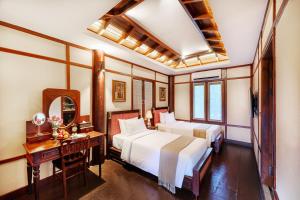 a hotel room with two beds and a desk at Phoum Chaufea Resort in Siem Reap