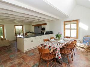 a kitchen and dining room with a table and chairs at Bryn Isaf in Ystrad Meurig