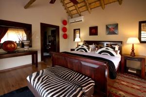 a bedroom with a zebra print bed in a room at Umzolozolo Private Safari Lodge & Spa in Nambiti Private Game Reserve