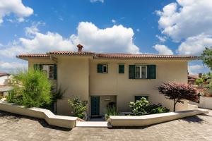 a house with green shutters and a roof at Beachside Villa Mia Apartments in Medveja +37 photos