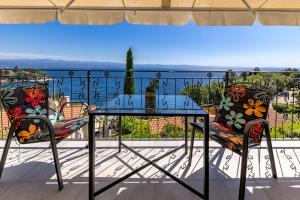 a glass table and two chairs on a balcony at Beachside Villa Mia Apartments in Medveja