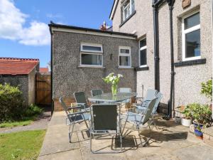 a patio with a table and chairs in front of a house at Gwynfa in Colwyn Bay