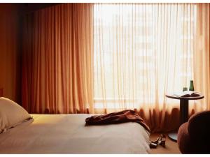 a bedroom with a bed and a large window at Hyde Melbourne Place in Melbourne