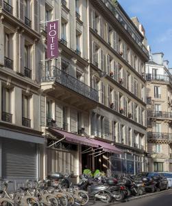 un grand bâtiment avec des motos garées devant lui dans l'établissement Hotel Andréa, à Paris