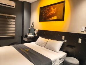 a hotel room with a bed and a yellow wall at Hoài Thu Luna Hotel in Ðông Hòa