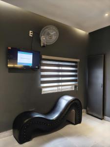 a black bench in a room with a flat screen tv at Hoài Thu Luna Hotel in Ðông Hòa