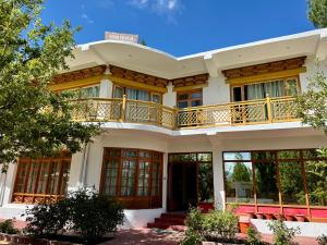 a large white house with a balcony at Hinjuma guest house in Leh