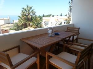 a wooden table and chairs on a balcony at Casa Ayty in Carvoeiro