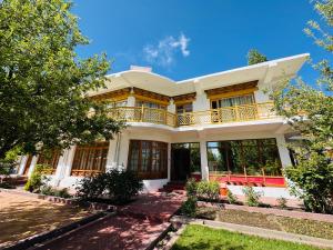 a large white house with a balcony at Hinjuma guest house in Leh