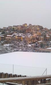 una ciudad cubierta de nieve con edificios en el fondo en Affittacamere Bellavista, en Castiglione di Sicilia