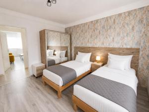 a hotel room with two beds and a mirror at Comfort 65 2-Bedroom Apartment with Balcony in Miskolc