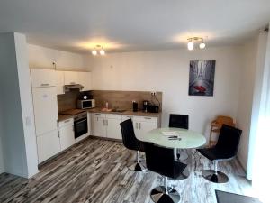 a kitchen with a table and chairs in a room at Ferienwohnung Schmidt mit Terrasse in Neustrelitz