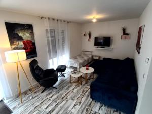 a living room with a blue couch and a chair at Ferienwohnung Schmidt mit Terrasse in Neustrelitz
