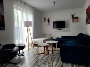 a living room with a blue couch and a tv at Ferienwohnung Schmidt mit Terrasse in Neustrelitz