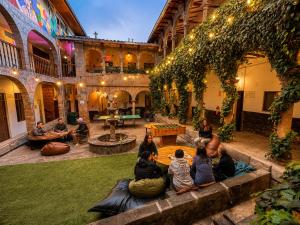 a group of people sitting in the courtyard of a building at Pariwana Hostel Cusco in Cusco +127 photos