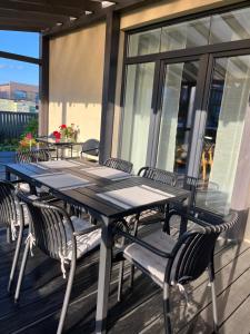 a black table and chairs on a deck at FAMILY HOUSE MARUPE in Mārupe