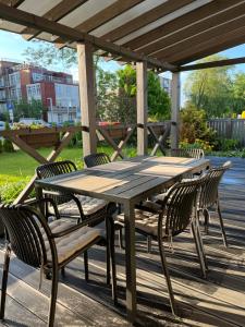 a wooden table and chairs under a pergola at FAMILY HOUSE MARUPE in Mārupe