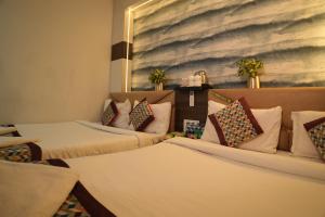 a room with two beds and a painting on the wall at Sanidhyam by Hotel Sahu near Temple in Varanasi +63 photos