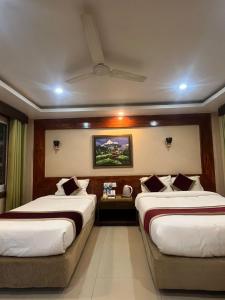 a hotel room with two beds and a television at Hotel Parkland in Sauraha +92 photos
