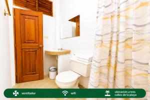 a bathroom with a toilet and a shower curtain at Suites Villa Colombia in Puerto López