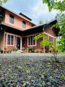a brick house with a driveway in front of it at Wayanad One in Wayanad
