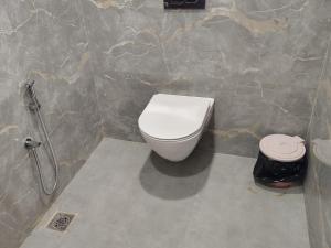 a bathroom with a toilet in a stone wall at Hotel SS Palace in Gaya +20 photos