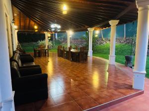 a covered patio with a table and chairs and a dining room at The Kings Villa in Kandy